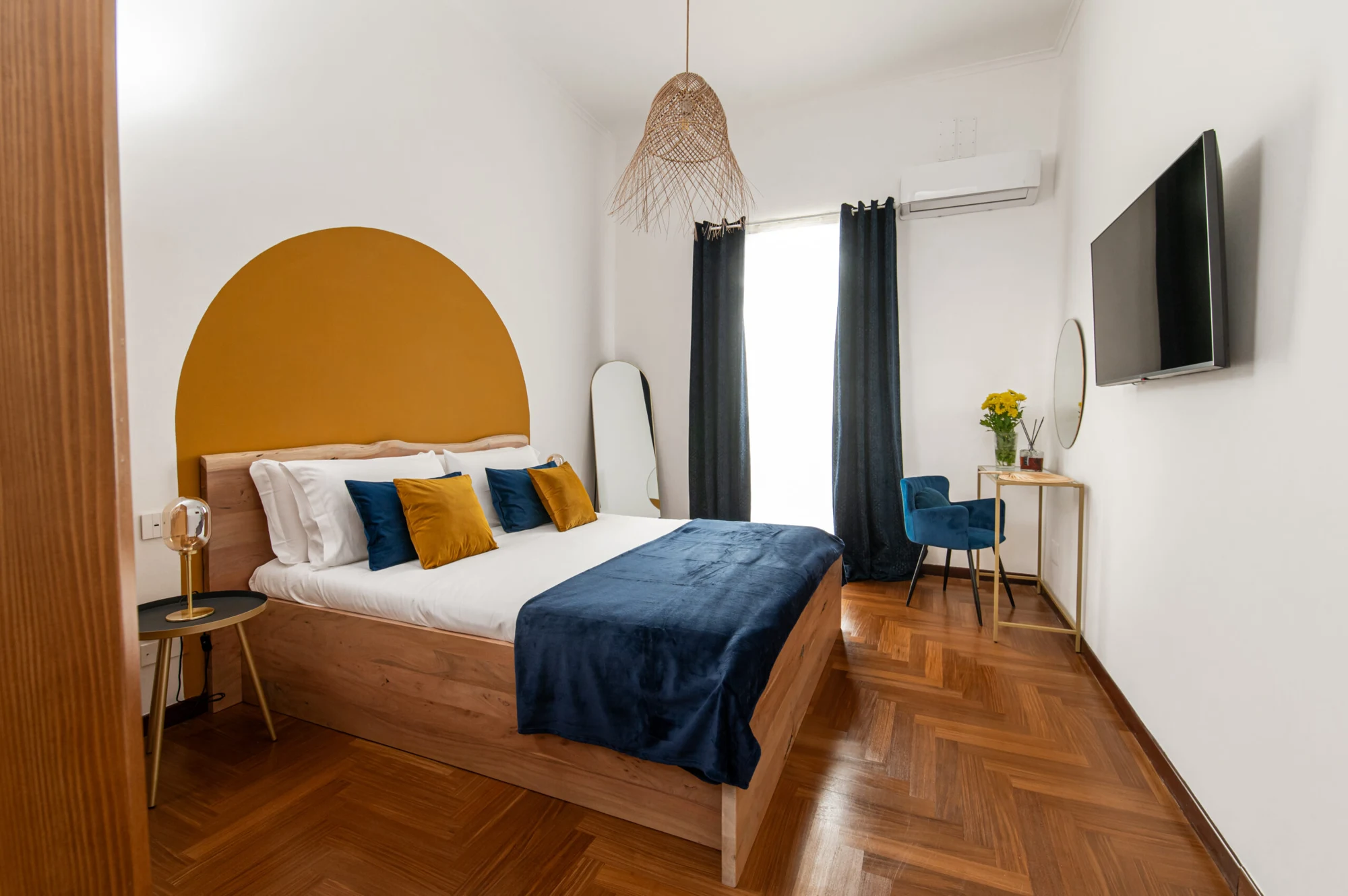 La camera di Quatrum Apartment con parquet, arredi blu e parete ocra